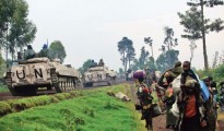 UN armoured vehicles drive past people fleeing renewed fighting between Congolese army and M23 rebels near the eastern Congolese city of Goma