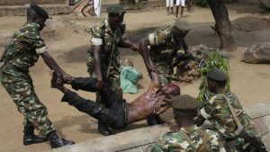 Les forces de l'ordre soulèvent un blessé présumé membre des milices IBONERAKURE attaqué par les manifestants