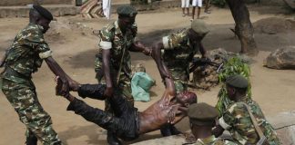 Les forces de l'ordre soulèvent un blessé présumé membre des milices IBONERAKURE attaqué par les manifestants