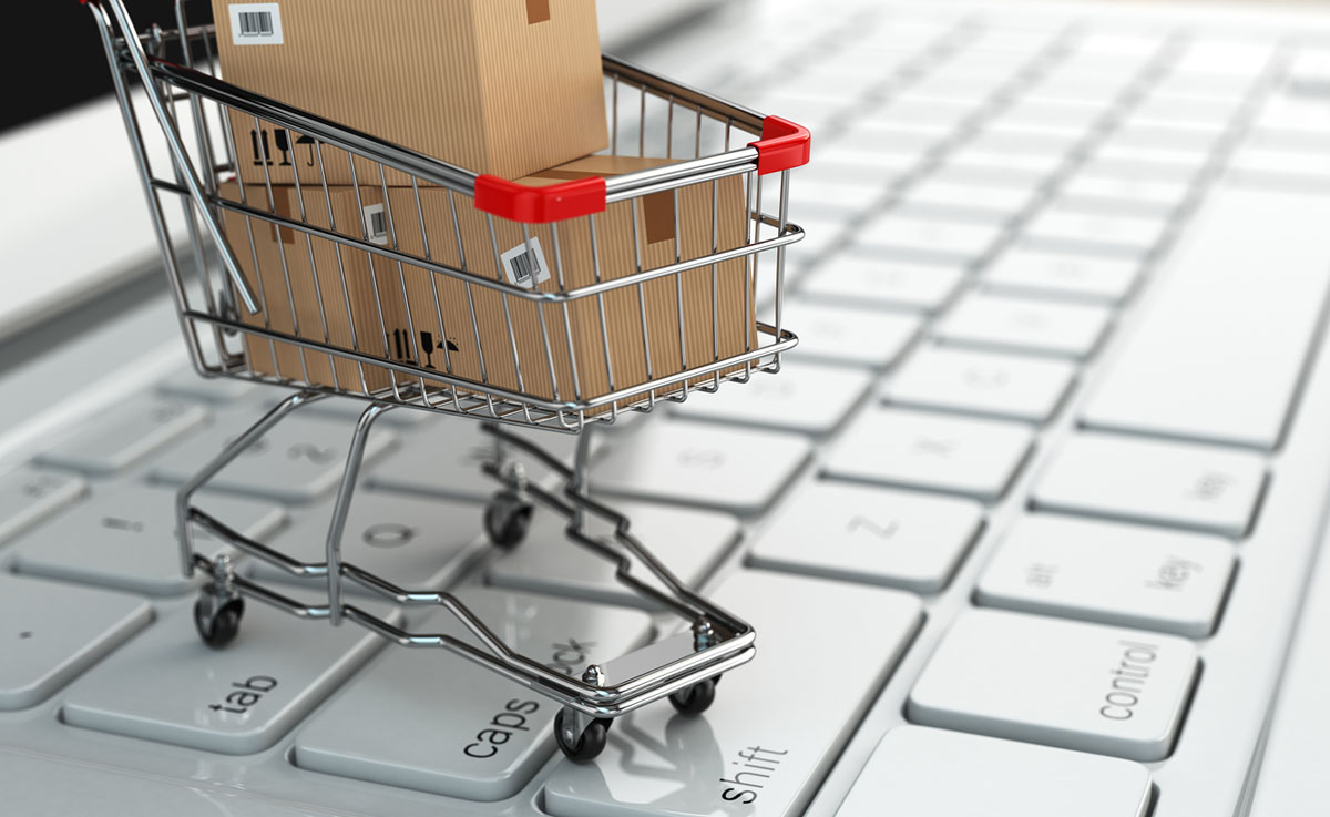 E-commerce. Shopping cart with cardboard boxes on laptop. 3d