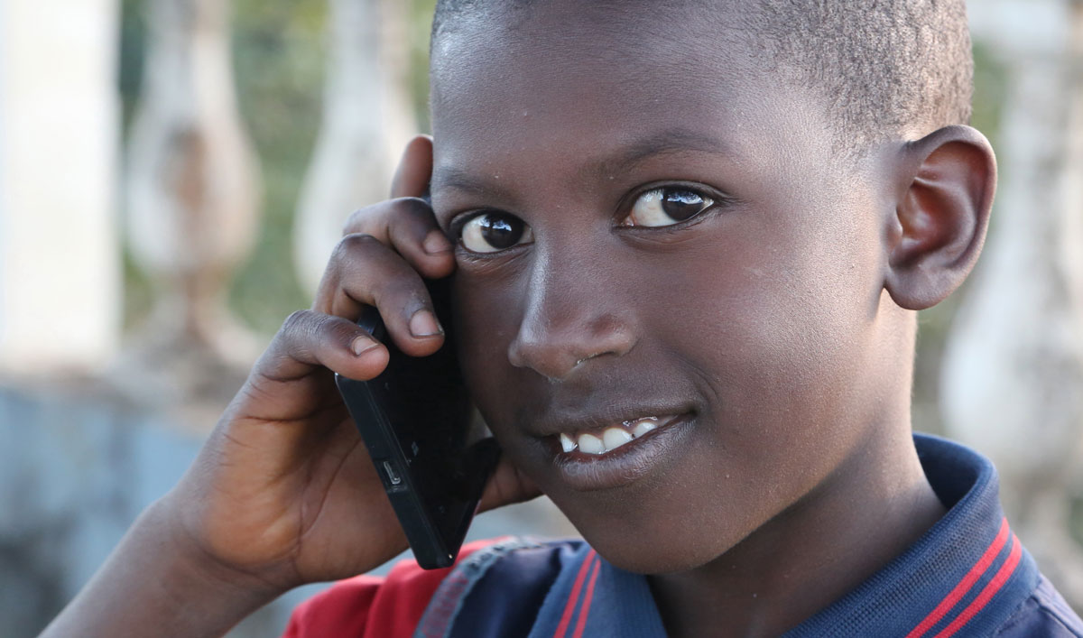 jeune-africain-telephone-mobile-afrique jeune africain avec un téléphone mobile en Guinée Conakry près de Dalaba