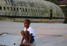 Enfant en Afrique sur un avion abandonné. Crédit photo Thierry Barbaut