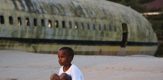 Enfant en Afrique sur un avion abandonné. Crédit photo Thierry Barbaut