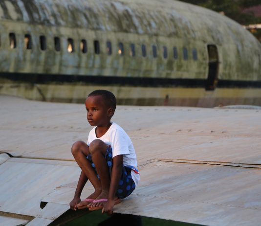 Enfant en Afrique sur un avion abandonné. Crédit photo Thierry Barbaut
