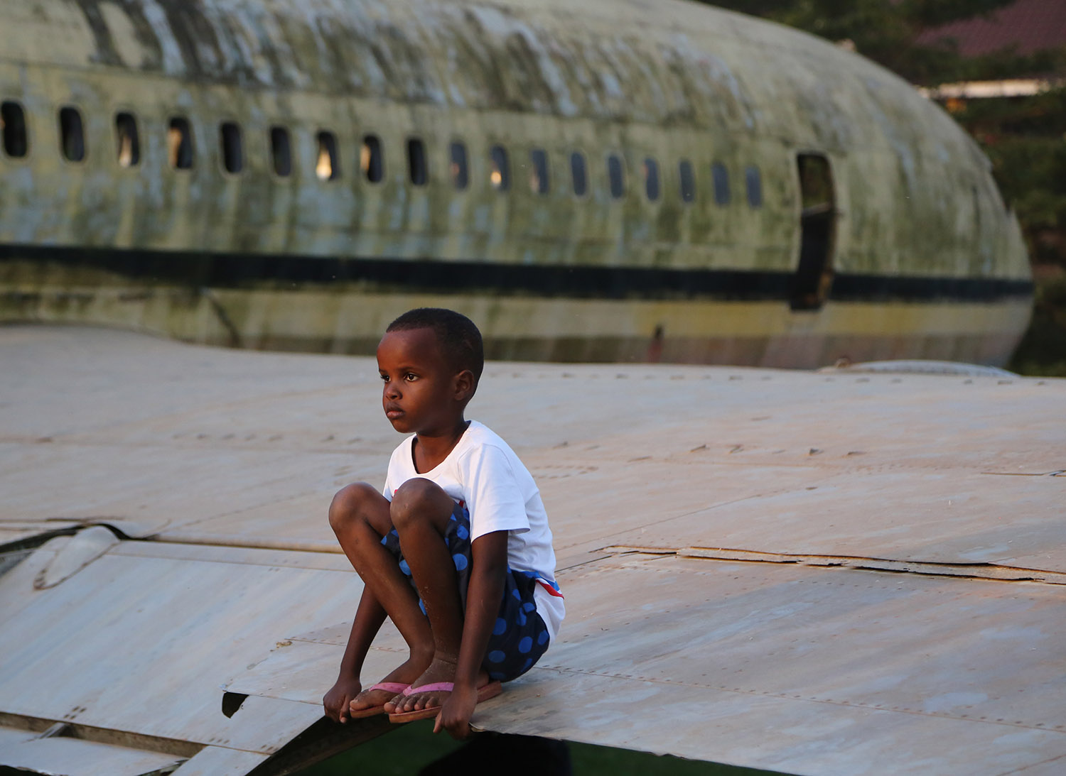 Enfant en Afrique sur un avion abandonné. Crédit photo Thierry Barbaut