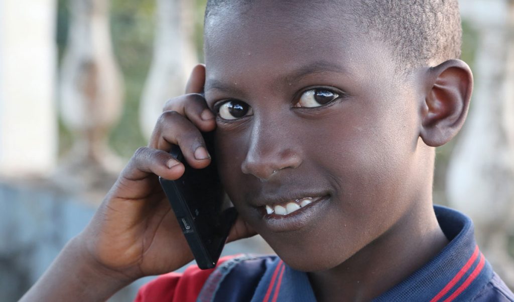 Un enfant au téléphone en Guinée - Crédit photo Thierry BARBAUT